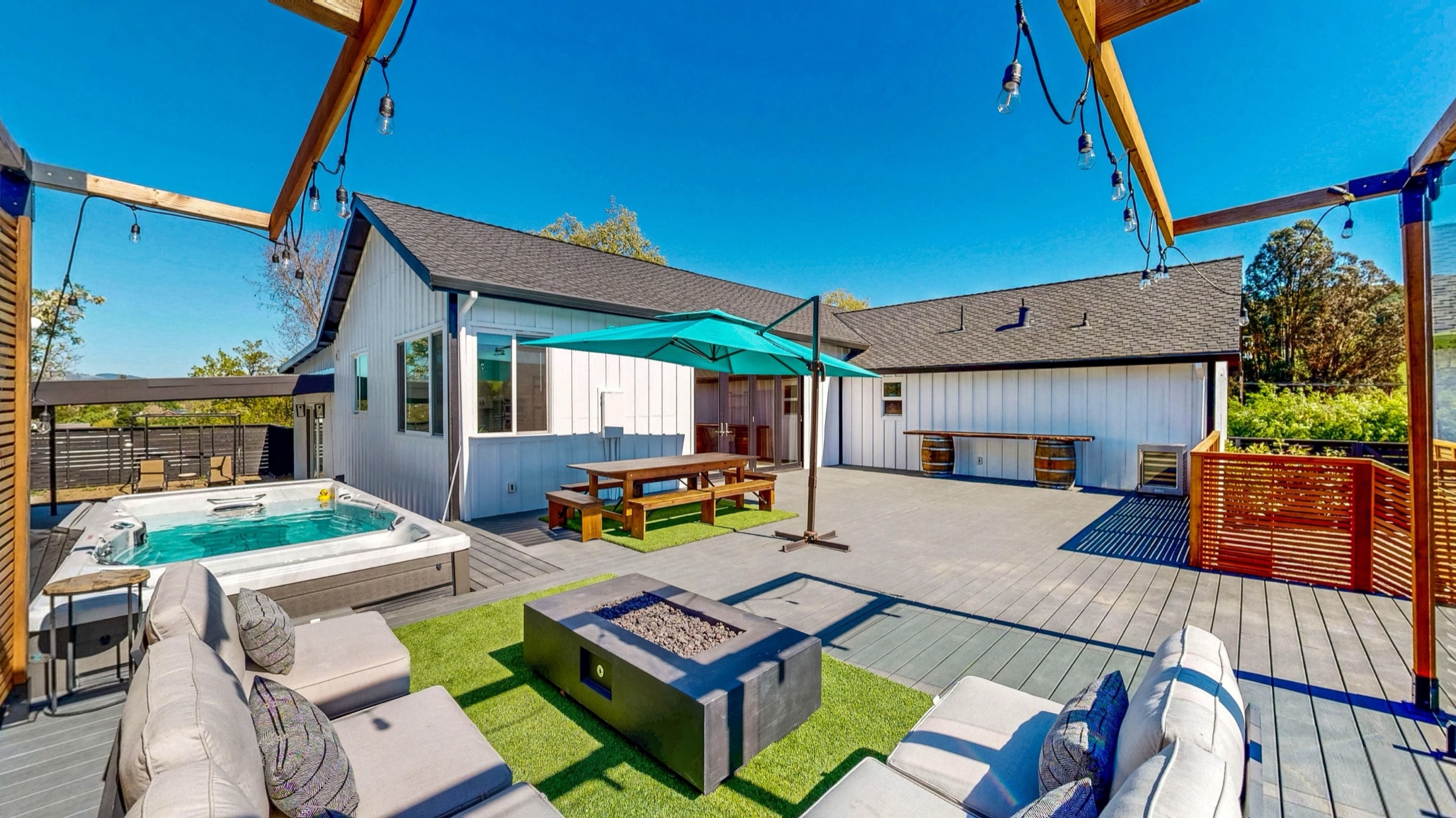 Courtyard with swim spa, fire-pit lounge, and string-lit pergolas at 2828 Western Avenue, Petaluma